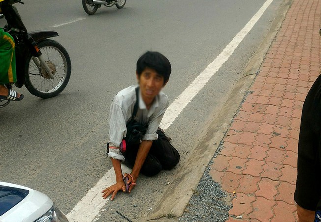 Một thanh niên giả tàn tật lết bán vé số