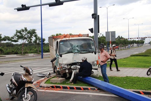 Húc xe taxi, xe tải chở gạch tông gãy trụ đèn