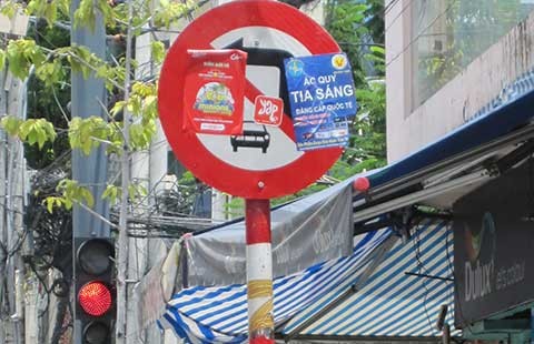 Tờ rơi nương mình che biển báo giao thông