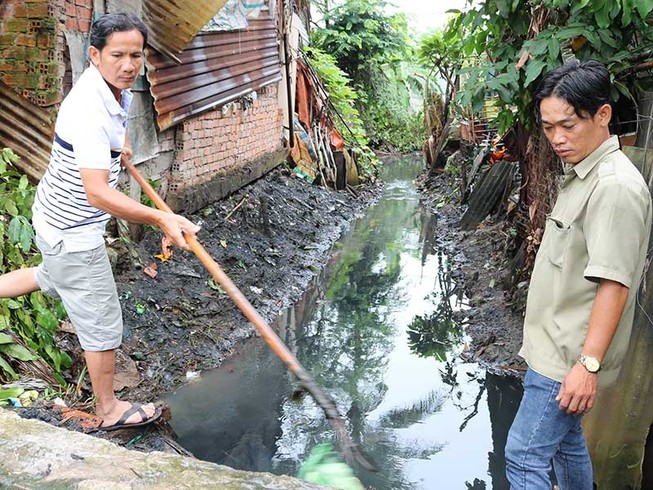 Ông Sang đi dọn kênh, chống ngập