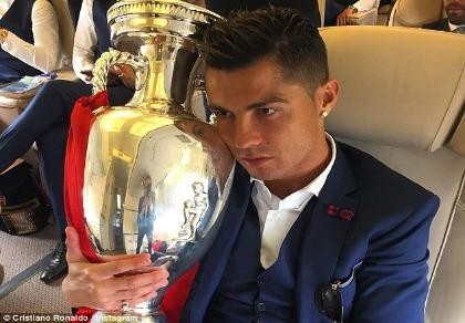 Ronaldo ôm khư khư cúp vô địch trên chuyến bay về nhà
