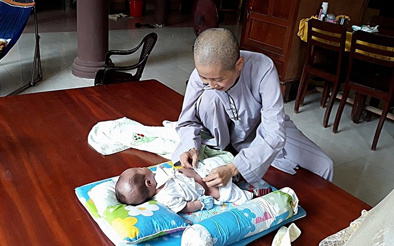 BÃ© trai quáº¥n trong khÄn bá» bá» rÆ¡i trÆ°á»c cá»ng chÃ¹a - áº£nh 1