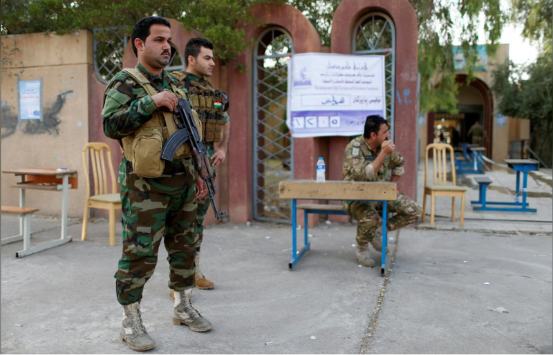 Bảo vệ an ninh khu vực bỏ phiếu trưng cầu dân ý ở Erbil (Iraq) ngày 25-9. Ảnh: REUTERS