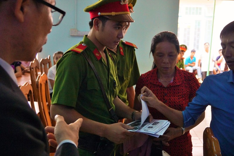 Công an và cán bộ tòa (áo xanh) đi gom báo... Ảnh: NGÂN NGA