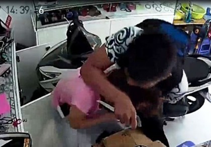 Tên cướp dí dao khống chế nhưng bị cô gái chống trả quyết liệt. Ảnh cắt từ camera.