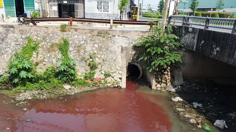 Nguồn nước đỏ chảy ra miệng cống dưới chân cầu bản Hy Vọng, đường Tân Sơn.
