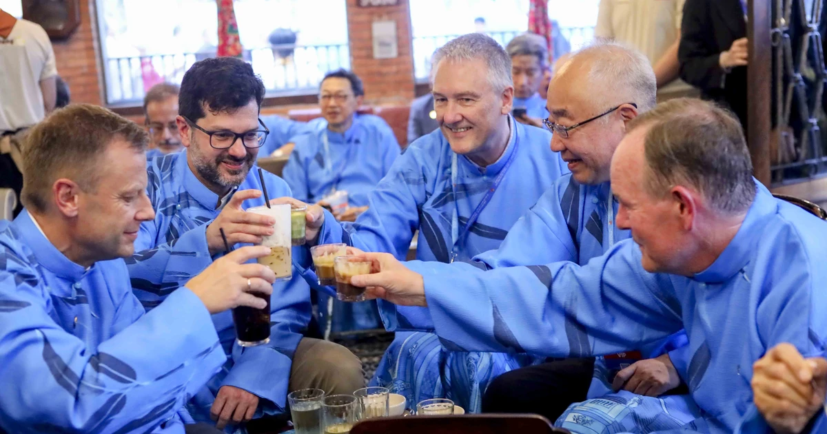 International delegates in long dresses enjoy egg coffee