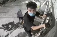 Một người trèo rào, một người cảnh giới để lấy trộm tài sản tại phường Hiệp Phú.