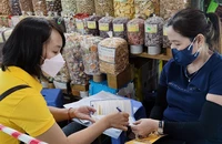 Nhân viên bưu điện tư vấn cho người dân về những quyền lợi khi tham gia BHXH tự nguyện.