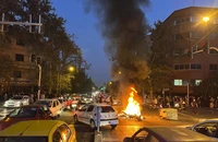 Người biểu tình đốt cháy xe cảnh sát Iran tại thủ đô Tehran (Iran) ngày 19-9. Ảnh: AP