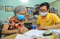 Người dân nhận lương hưu tại nhà. Ảnh: T.HƯƠNG