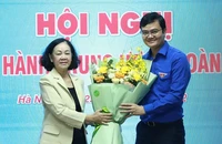 Bà Trương Thị Mai - ủy viên Bộ Chính trị, bí thư Trung ương Đảng, trưởng Ban Tổ chức Trung ương - trao hoa chúc mừng tân Bí thư thứ nhất Trung ương Đoàn Bùi Quang Huy - Ảnh: TTO