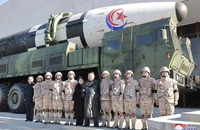 Nhà lãnh đạo Triều Tiên Kim Jong-un chụp ảnh cùng con gái và các binh sĩ trước tên lửa đạn đạo xuyên lục địa Hwasong-17. Ảnh: KCNA