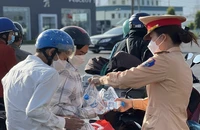 CSGT Đồng Nai tặng mũ bảo hiểm, phát nước suối, khăn lạnh cho người dân