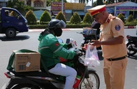 CSGT 'đội nắng' phát nước miễn phí cho người dân về quê nghỉ lễ 30-4