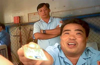 Ông Phan Ngọc Sơn, tổ phó tổ Trật tự đô thị, làm việc với người vi phạm dưới sự giám sát của tổ trưởng. Ảnh: TÂN - YÊN