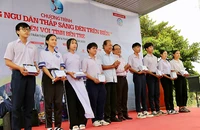 Ông Trương Hòa Bình, nguyên Phó Thủ tướng thường trực Chính phủ, Chủ tịch danh dự của chương trình, cùng ông Mai Ngọc Phước, Tổng Biên tập báo Pháp Luật TP.HCM, trao học bổng cho con em ngư dân tỉnh Bến Tre.