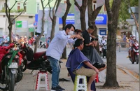 Người dân đến cắt tóc tại khu vực công viên Bình Phú (đường Nguyễn Văn Luông, quận 6, TP.HCM). Ảnh: MINH THUẬN
