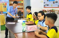 Thầy Lê Tấn Phát trong giờ dạy miễn phí cho các em nhỏ tại xóm trọ công nhân ở quận 4. Ảnh: VÕ THƠ