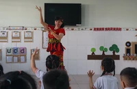 Cô Võ Thị Mỹ Dung, giáo viên Trường Mầm non Anh Đào, quận Gò Vấp (người nhận giải thưởng Võ Trường Toản năm nay) đang dạy múa cho học trò. Ảnh: NGUYỄN QUYÊN