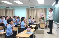 Thầy Phạm Kiên Thành, giáo viên Trường THCS Lý Tự Trọng, quận Gò Vấp, cùng học sinh khởi động đầu tiết học. Ảnh: NGUYỄN QUYÊN