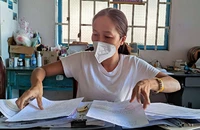Bà S bên đống hồ sơ sau gần hai năm chưa được giao con theo bản án của tòa.