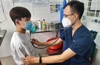 BS Phạm Duy Tín đang khám cho một trẻ em ở xã Tân Hiệp, huyện Hóc Môn, TP.HCM. Ảnh: TRẦN NGỌC