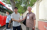 Ông Lê Trường Sơn (trái) động viên, dặn dò cán bộ, giảng viên trước giờ khởi hành đi Bình Thuận làm công tác kiểm tra thi.