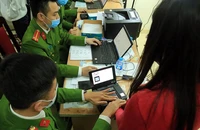 Lực lượng công an làm thủ tục cấp CCCD gắn chip cho người dân.