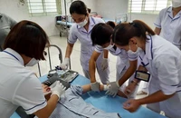 Các điều dưỡng đang cố gắng cho một bệnh nhân tâm thần uống thuốc khi người này không chịu hợp tác.