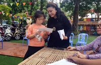 NSND Kim Cương tặng tiền hỗ trợ các trẻ em.