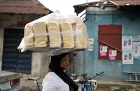 Một phụ nữ bán bánh mì trên đường phố TP Lagos (Nigeria) ngày 3-2.