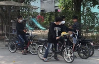 Các học sinh tụ tập thử xe đạp điện.