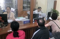 Cán bộ phường Hoàng Liệt, quận Hoàng Mai làm thủ tục hành chính cho người dân sáng 20-3.