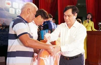 Ông Phan Xuân Thủy, Phó Trưởng ban Tuyên giáo Trung ương, đang trao các phần quà có ý nghĩa thiết thực của chương trình đến ngư dân Ninh Thuận.