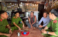 Già làng Điểu Mpiăr (giữa) trò chuyện với cán bộ công an.