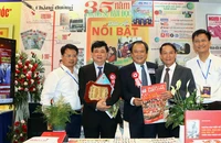 Ông Mai Ngọc Phước, Tổng Biên tập báo Pháp Luật TP.HCM (giữa), chụp ảnh cùng các đại biểu tham quan gian trưng bày báo Pháp Luật TP.HCM, tại Hội Báo toàn quốc 2025.