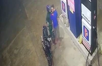 Kẻ cướp kề liềm vào cổ, cướp tiền của nhân viên cây xăng. Ảnh chụp màn hình