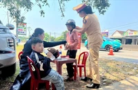 CSGT Quảng Nam phát nước, khăn lạnh cho người dân về quê nghỉ lễ. Ảnh: TN