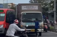 Tài xế xe tải chặn xe, cầm thanh sắt thách thức tài xế xe buýt. Ảnh: TN