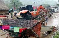 Xe tải chở xe múc va vào cổng chào làm sập, đè phần cabin xe tải. Ảnh: TN