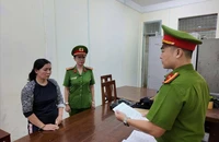 Công an đọc lệnh bắt bị can. Ảnh: CA