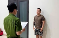 Cảnh sát đọc lệnh bắt đối với Dương. Ảnh: CA