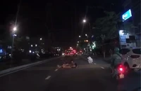 Hai người đi xe máy ngã nhào ra đường. Ảnh: TN