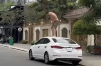 Người đàn ông đứng trên nóc ô tô đập phá. Ảnh: TN