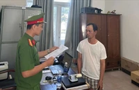 Công an đọc lệnh bắt Danh. Ảnh: CA