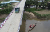 Xe chở cát qua cầu, còn người dân phải thuê đò qua sông