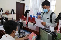 Người dân sử dụng sổ hộ khẩu để xác thực thông tin về nơi cư trú. Ảnh: HOÀNG GIANG