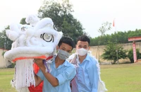 Tú và Tài tập múa lân trong sân trường.