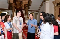 Ông Phan Văn Mãi trò chuyện với du khách tham quan trụ sở HĐND và UBND TP.HCM